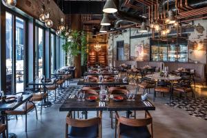 a restaurant with tables and chairs in a room with windows at CITYWALK DUBAI Downtown in Dubai