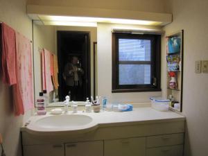 a person taking a picture of a bathroom sink at Ken House Osaka in Takatsuki