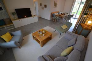 ein Wohnzimmer mit Sofa und Tisch in der Unterkunft La Bulle Emeraude, détente à deux, en famille ou entre amis in Plancoët