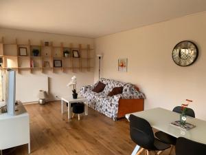 ein Wohnzimmer mit einem Bett und einem Tisch in der Unterkunft Superbe appartement 3 pièces 57 m2 avec Terrasse 33m2 in Levallois-Perret