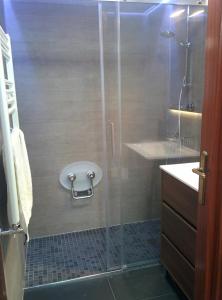 y baño con ducha y puerta de cristal. en Apartamentos Zarautz Playa, con piscina y garaje, en Zarautz