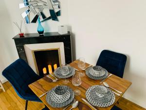 une table en bois avec des assiettes et des verres au-dessus dans l'établissement Nice cocooning apartment for a relaxing moment, à Reims