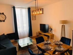 - un salon avec une table et une télévision dans l'établissement Nice cocooning apartment for a relaxing moment, à Reims