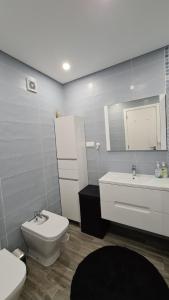 a bathroom with a white toilet and a sink at Consolação Beach Apartment in Peniche