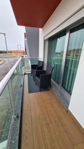 een balkon van een gebouw met stoelen en ramen bij Consolação Beach Apartment in Peniche