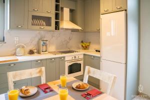 a kitchen with a table and a white refrigerator at Aphrodite’s Cozy House in Kolymvari
