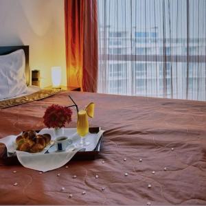 un vassoio di cibo e bevande su un letto di Atlantis Resort Sea View a Burgas