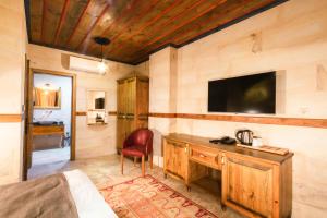 a bedroom with a desk and a tv on a wall at Sapphire Stone hotel in Göreme