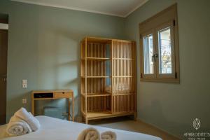 a bedroom with a bed and a book shelf and a window at Aphrodite’s Cozy House in Kolymvari
