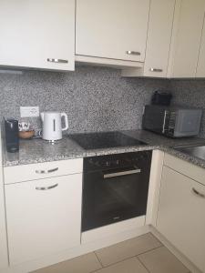 a kitchen with white cabinets and a black stove top oven at Attico Bellavista in Locarno