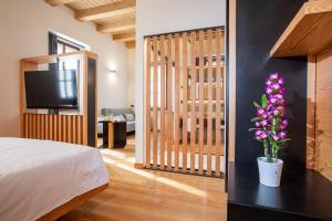 a bedroom with a bed and a tv and flowers at Villa Giade in Chiavenna