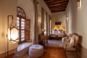 een woonkamer met een bank en een bed bij Riad Bohémia in Marrakesh