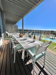 einen weißen Tisch und Stühle auf einer Terrasse mit Aussicht in der Unterkunft Superbe appartement spacieux avec terrasse vue piscine in Vilamoura