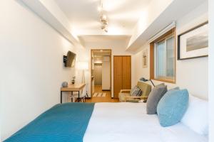 a bedroom with a large bed with blue pillows at Dash Living Shinjuku in Tokyo