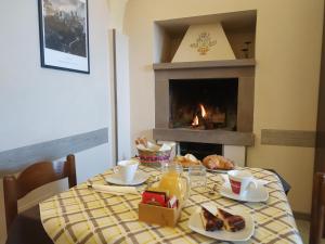 a table with a breakfast of bread and a fireplace at Locanda Prato d'Era in Volterra