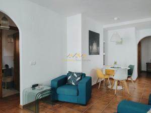 sala de estar con silla azul y mesa en Lovely 2 bedroomed apartment with pool, en Frigiliana
