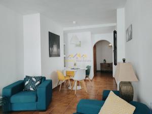 sala de estar con sofá azul y mesa en Lovely 2 bedroomed apartment with pool, en Frigiliana