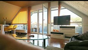 a living room with a tv and a glass table at Ferienwohnung Edermündung in Haldorf