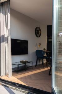 een woonkamer met een flatscreen-tv aan de muur bij Strand, Zee & Meer in Vrouwenpolder