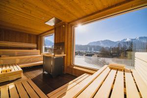 eine Sauna mit Bänken und einem großen Fenster in der Unterkunft Spa&Aktiv Hotel Lavendel in Windischgarsten