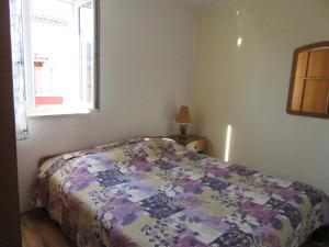 een slaapkamer met een bed met een quilt bij Apartment Antonio in Pula