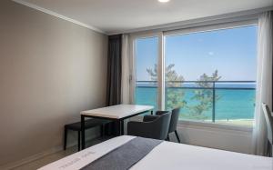 a hotel room with a table and a view of the ocean at Gyeongpo Soo Hotel in Gangneung