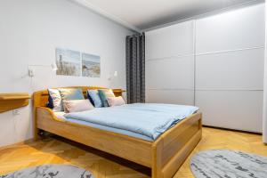 a bedroom with a bed with blue sheets and pillows at Apartments Letná, AC & garage 89m2 and 44m2 in Košice