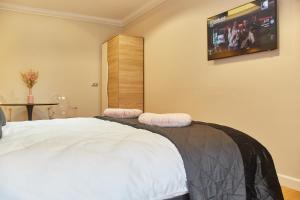 a bedroom with a bed with a tv on the wall at Apartament TANGO la casa PIANO HOUSE ,cu parcare in Alba Iulia