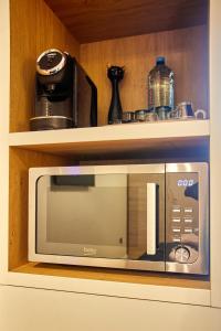 a microwave sitting on a shelf in a kitchen at Apartament TANGO la casa PIANO HOUSE ,cu parcare in Alba Iulia