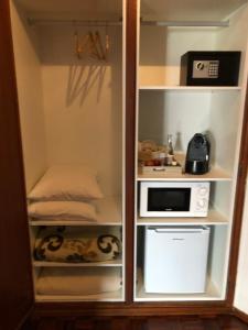 a small kitchen with a microwave and refrigerator at HOTEL BOUTIQUE a ESPLANADA in Castelo Branco