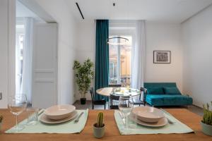 a living room with a table and a blue couch at Mag 179 Bed & Spa in Palermo