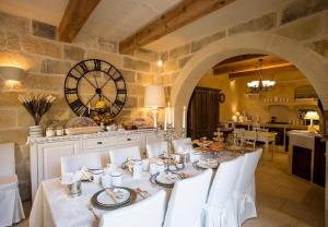 a dining room with a table and a large clock at Betty Cake B&B in Qala