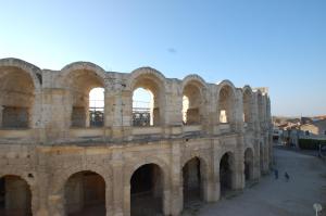 un vieux bâtiment avec des arches dans une ville dans l'établissement Rêv'Arles Maison de charmes aux Arènes, à Arles