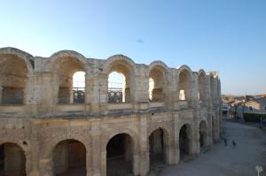 an old building with arches in a city at Rêv'Arles Maison de charmes aux Arènes in Arles