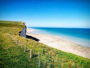 a fence on the side of a beach with the ocean at la baie le Rue in Rue