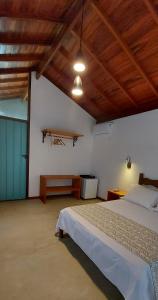 a bedroom with a bed and a wooden ceiling at Paiol Eco Suites in Paraty