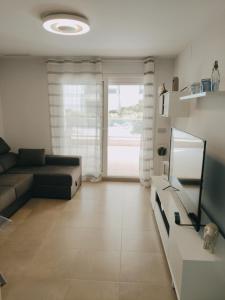 sala de estar con sofá y ventana grande en Maríahome, en Almería