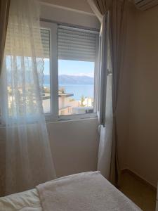 Schlafzimmer mit einem Fenster mit Meerblick in der Unterkunft Apartament Orestiada in Vlorë