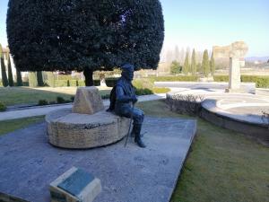 a statue of a man sitting on a bench at LeDolciTerme in Rapolano Terme