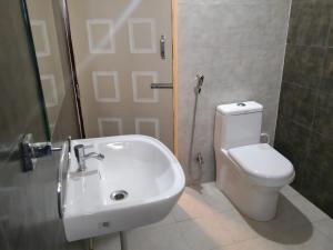 a bathroom with a sink and a toilet and a shower at AMULYA FINE DINE RESIDENCY in Bangalore