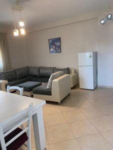 ein Wohnzimmer mit einem Sofa und einem Kühlschrank in der Unterkunft Apartament Orestiada in Vlorë