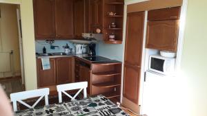 a small kitchen with wooden cabinets and a table and chairs at Studio mummola in Varkaus