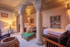 een slaapkamer met 2 bedden en een pilaar bij Riad Bohémia in Marrakesh