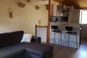 a living room with a couch and a kitchen at Duplex au centre ville, dans cour intérieure calme in Dole