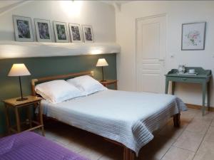 a bedroom with a large bed and a table at Clos de l'Arthonnet- Chambres d'hôtes avec cuisine d'été, proche Limoges in Flavignac