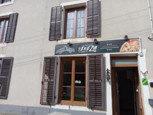 a pizza shop with a sign on the side of a building at Jonquille Chic La Piccola Venezia in Vrécourt