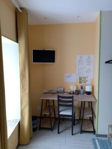 a room with a table and a tv on the wall at Jonquille Chic La Piccola Venezia in Vrécourt