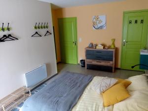 a bedroom with green doors and a bed and a dresser at Jonquille Chic La Piccola Venezia in Vrécourt