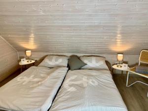 a bed in a room with two tables and two lamps at Idylle Seepark - Haus mit Pool und Fasssauna in Kirchheim