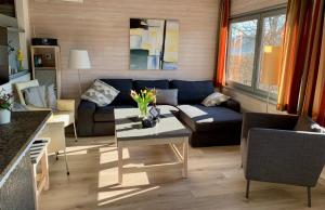 a living room with a couch and a table at Idylle Seepark - Haus mit Pool und Fasssauna in Kirchheim
